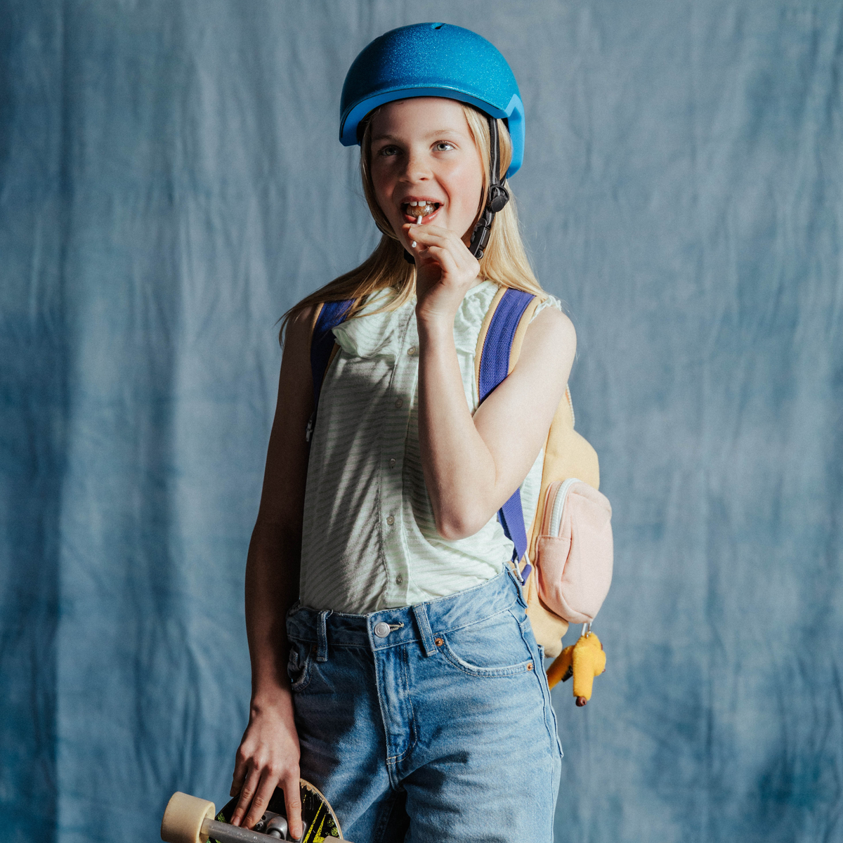 Meisje met blauwe refelecterende kinderfietshelm, helemaal klaar voor een veilige fietsrit naar school