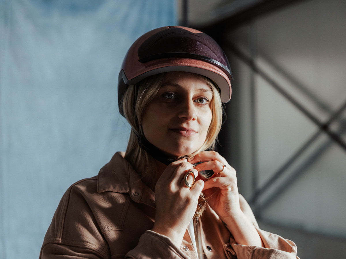 Roze fietshelm voor dames voorzien van een zonneklep die magnetisch kan bevestigd worden